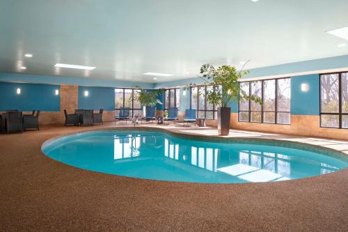 a pool in the middle of a large room with windows at Hampton Inn Chicopee - Springfield in Chicopee