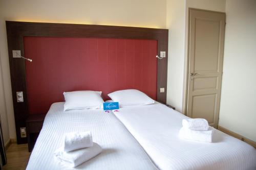a bedroom with a large white bed with towels on it at Clarion Aparthotel Toulouse Blagnac Airport in Blagnac