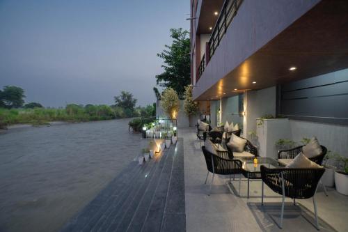 a restaurant with tables and chairs next to a river at Sukoon by The Ganges with Private Ganga Ghat in Haridwār