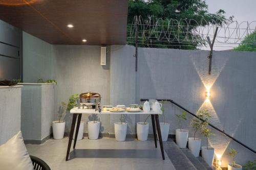 a patio with a table and potted plants at Sukoon by The Ganges with Private Ganga Ghat in Haridwār