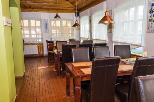 a dining room with a wooden table and chairs at Ötösfogat Panzió in Siófok