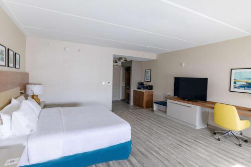 a hotel room with a bed and a television at Hilton Garden Inn Lakewood in Lakewood