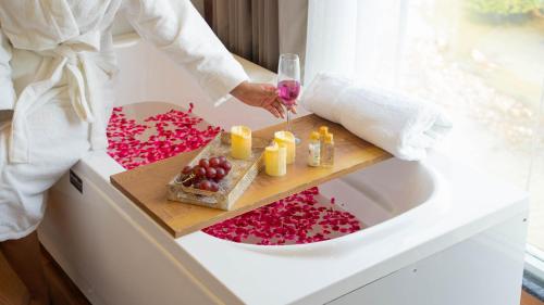 a person in a bathroom with a table with pink petals at Sukoon by The Ganges with Private Ganga Ghat in Haridwār