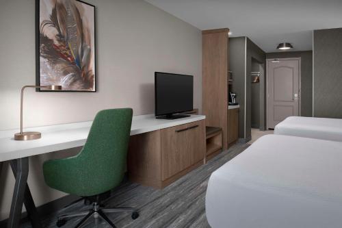 a room with a bed and a desk with a television at Hilton Garden Inn Casper in Casper