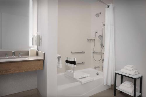 a white bathroom with a shower and a sink at Hilton Garden Inn Casper in Casper