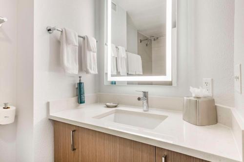 a white bathroom with a sink and a mirror at Hilton Grand Vacations Club Paradise Las Vegas in Las Vegas
