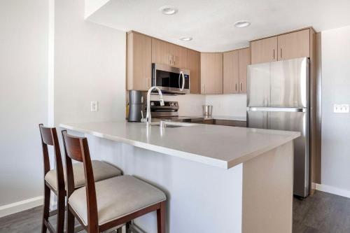 a kitchen with a large counter with chairs and a refrigerator at Hilton Grand Vacations Club Paradise Las Vegas in Las Vegas