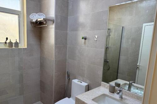 a bathroom with a shower and a toilet and a sink at New 4-Bedroom Villa in Shakhbout City in Abu Dhabi Intl