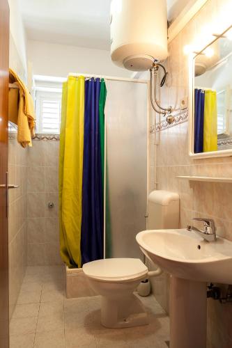 a bathroom with a shower curtain and a sink at Apartment Lidija in Podgora