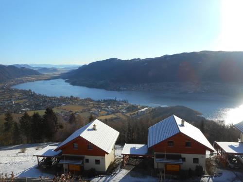 a couple of houses on a hill with a lake at Villa Relax am See in Bodensdorf
