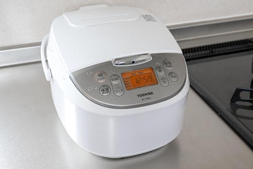 a white toaster sitting on a counter with an orange clock at RIZOTIA Kakizaki in Katamachi