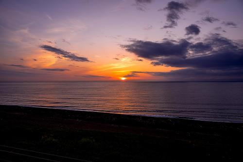 a sunset over the ocean with the sun setting at RIZOTIA Kakizaki in Katamachi