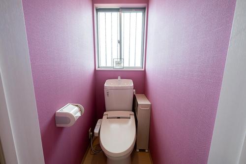 a purple bathroom with a toilet and a window at RIZOTIA Kakizaki in Katamachi
