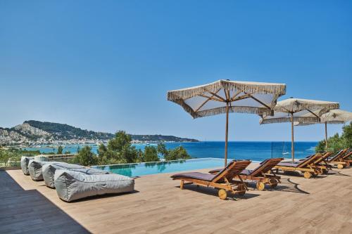 a group of chairs and umbrellas on a swimming pool at Althea Lavish Estate - Villa & Suite in Zakynthos Town