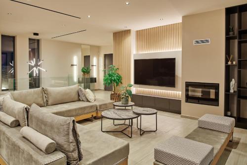 a living room with a couch and a tv at Althea Lavish Estate - Villa & Suite in Zakynthos Town