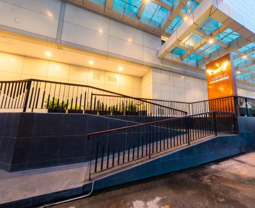 a lobby with a staircase in a building at Astara Hotel Balikpapan in Balikpapan