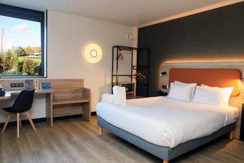 a hotel room with a large bed and a desk at Campanile Toulouse Balma - Cité de l'Espace in Toulouse