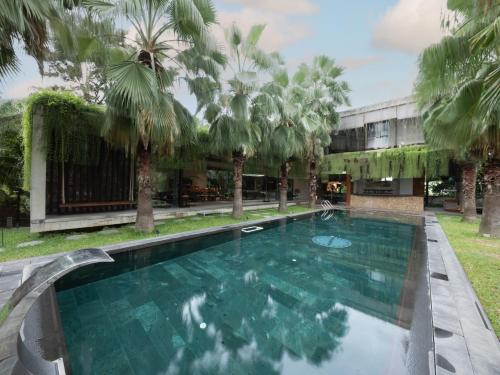 a swimming pool in front of a building with palm trees at Palm Villa in Nha Trang