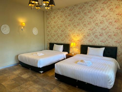 a room with two beds in a room with at วิลล่า พิคทอรี่ in Ban Nong Chap Tao