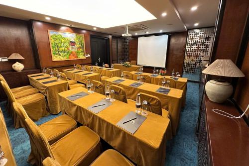 a conference room with tables and chairs and a screen at Thang Long Opera Hotel in Hanoi