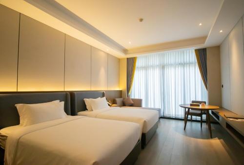 a hotel room with two beds and a table at DongHu Resort Hotel in Sihanoukville