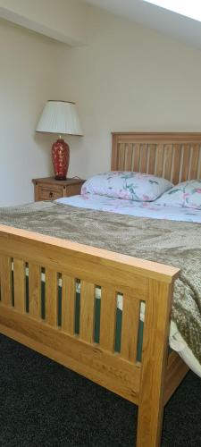 a bedroom with a bed and a table with a lamp at Greystones nawab A B C units sleeps upto 14 ,15 buxton in peak park in Hurdlow Station