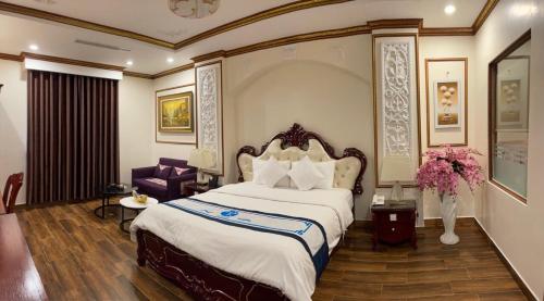 a hotel room with a large bed and a chair at Khách sạn Trung Kiên in Hai Phong