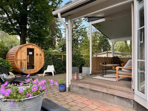a patio with a barrelarmaarmaarmaarmaarmaarmaarmaarmaarmaarmaarma at Het Verwende Nest met privé hottub & Barrel sauna in Voorthuizen