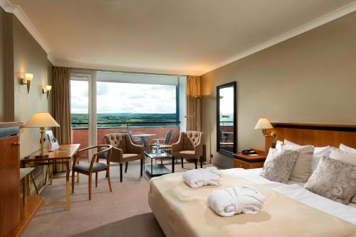 a hotel room with a bed with towels on it at Wyndham Garden Lahnstein Koblenz in Koblenz