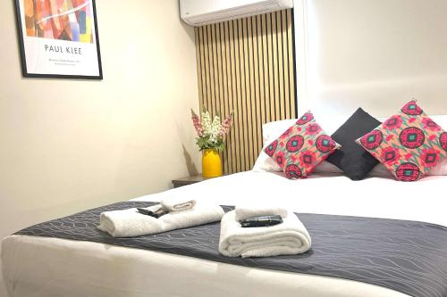 a bedroom with a bed with towels on it at Comfort Inn Serenity Bathurst in Bathurst