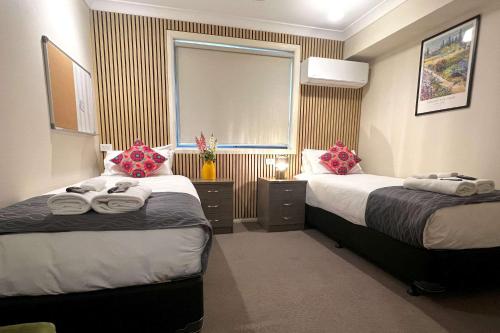 a hotel room with two beds and a window at Comfort Inn Serenity Bathurst in Bathurst