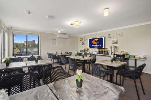 a dining room with tables and chairs in a restaurant at Comfort Inn Serenity Bathurst in Bathurst