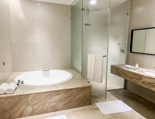 a bathroom with a tub and a glass shower at All-Ur Boutique Motel - Taichung Branch in Taichung