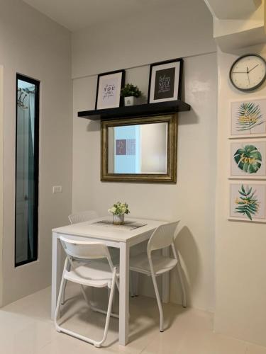 a white table and chairs in a room with a clock at Modern Condo, Sea View, Fast Wifi, Cafe, Panglao in Dauis