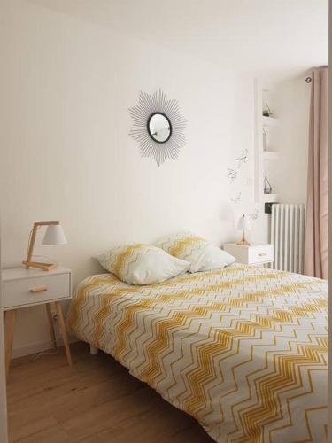 une chambre avec un lit et un miroir au mur dans l'établissement COCON du centre ville avec PARKING et WIFI, à Millau