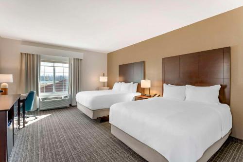 a hotel room with two beds and a desk at Comfort Inn & Suites Verona at Turning Stone Resort Casino in Verona