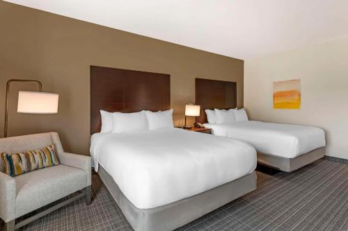 a hotel room with two beds and a chair at Comfort Inn & Suites Verona at Turning Stone Resort Casino in Verona