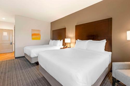a hotel room with two beds and a chair at Comfort Inn & Suites Verona at Turning Stone Resort Casino in Verona
