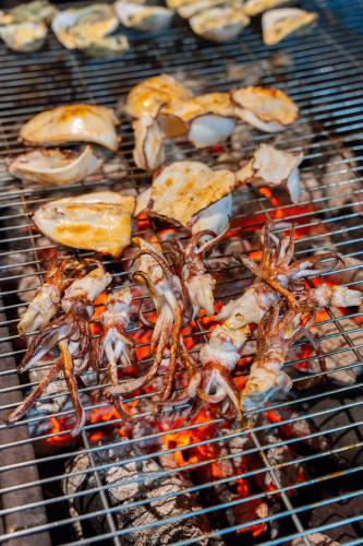 a bunch of food cooking on a grill at Palm Villa in Nha Trang