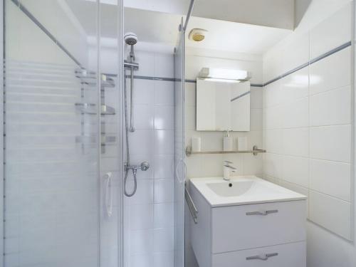 a white bathroom with a sink and a shower at Saint-Hilaire - 350m de la plage in Plage-des-Demoiselles