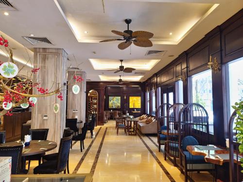a restaurant with tables and chairs and a ceiling fan at Thang Long Opera Hotel in Hanoi