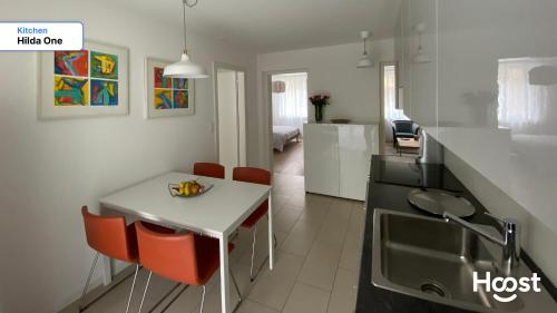 a kitchen with a white table and red chairs at H1 with 4,5 Room, Bathroom, Kitchen, Central, quiet & modern with office in Zürich