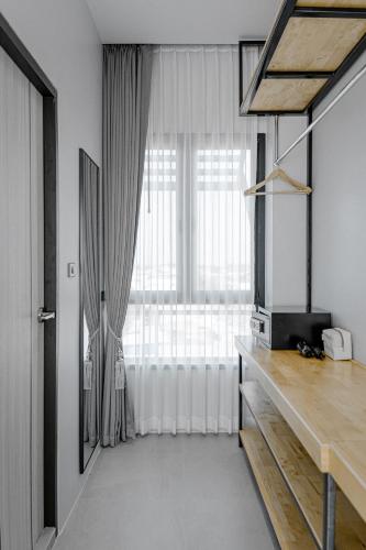 a living room with a large window and a television at The Horizon Groove Hotel in Ban Khlong