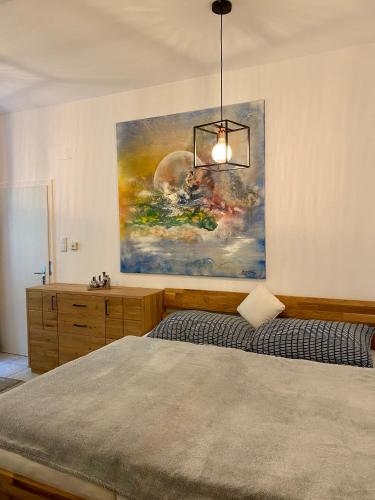 a bedroom with a painting on the wall and a bed at Atelier Lomani in Vienna