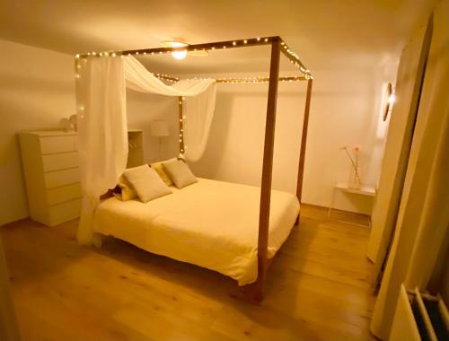 a bedroom with a canopy bed with lights on it at Estrella dreams in Amblève