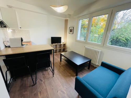 - un salon avec un bureau et un canapé bleu dans l'établissement Wolk, Joli appt une chambre, à Caen