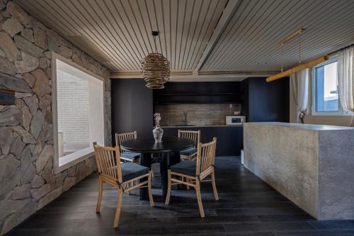 a dining room with a table and chairs and a stone wall at 无终隅民宿 in Jizhou