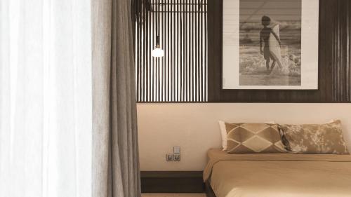 a bedroom with a bed and a picture of a woman at New Little Ripper Boutique Hotel in Tanah Lot