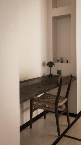 a wooden desk with a chair and a lamp at New Little Ripper Boutique Hotel in Tanah Lot