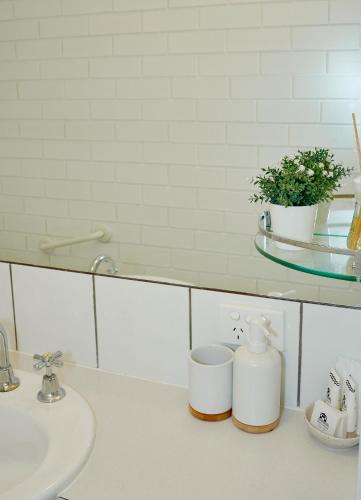 a bathroom counter with a sink and a mirror at Arlingtons Holiday Accommodation in Portarlington